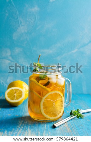 Iced lemon tea on blue background. Space for text
