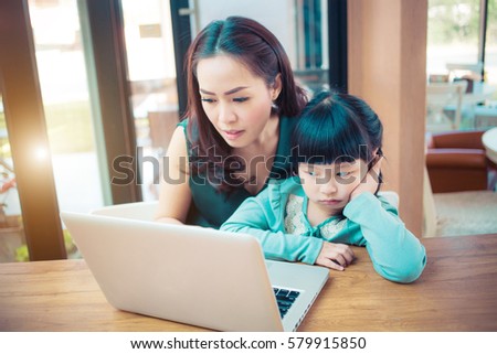 Little girl looking at laptop computer with her mom.Concept family happy.