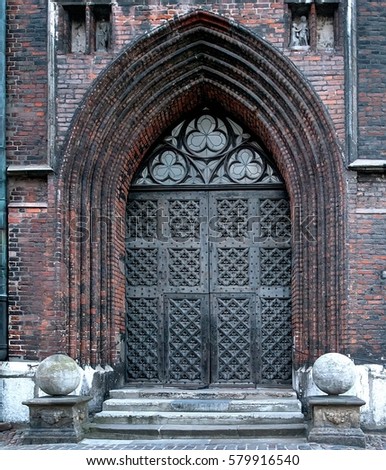 Ancient metal door with portal of gothic church
