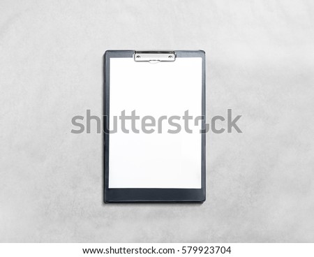 Blank black clipboard with white pages mockup, isolated in textured background. Empty document holder mock up lying on grey desk. Clear clip board organizer template. Office stationery notebook design Royalty-Free Stock Photo #579923704