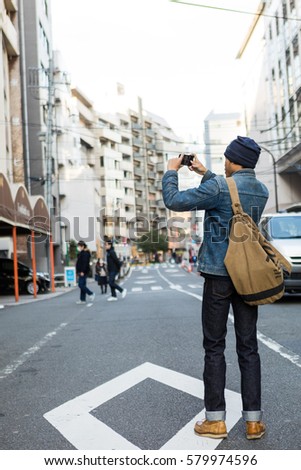 Asian man take photo with smartphone, Tokyo, Japan. 