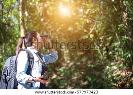 Traveler woman look binoculars on the forest, background forest Thailand, select and soft focus