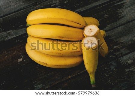 Bunch of fresh bananas on an old wooden table. Selective focus and small depth of field.