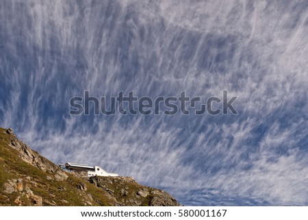 Blue cloudscape over mountain with cable car stop