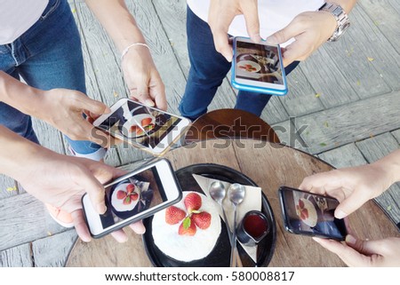 Business conceptual- Photo of Hipster gangster using smart phone taking photo on strawberry dessert,Vintage tone