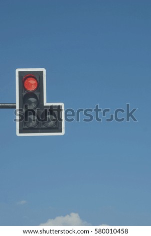 Red Traffic Light against Blue Sky Background 