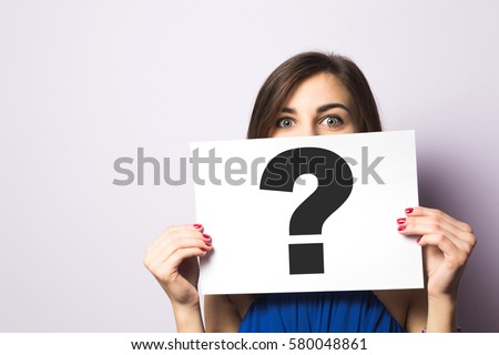 Girl holding a signboard with a question mark Royalty-Free Stock Photo #580048861