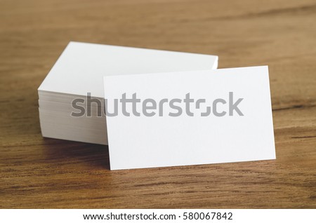 Blank business cards on brown wooden table.