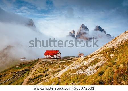 Foggy view of the National park Tre Cime di Lavaredo with rifugio Locatelli. Dramatic and gorgeous scene. Location place famous resort Auronzo, Dolomiti alps, South Tyrol, Italy, Europe. Beauty world.