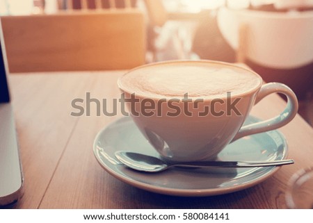 Cup of coffe on workplace desk, coffee cafe shop.