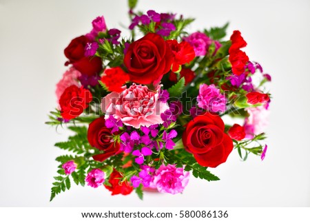 Red flowers bouquet in a vase on a white background