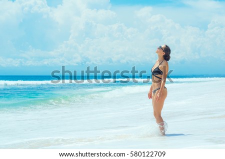 Beautiful young woman in bikini on the exotic beach at blue lagoon 