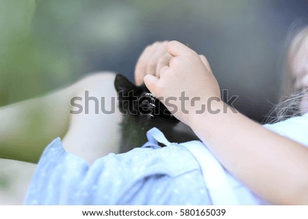 girl with a black kitten playing / lying on the couch