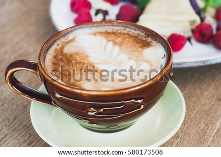 A cup of coffee with a picture on the coffee foam