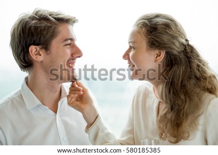 Cheerful woman pinching chin of her boyfriend