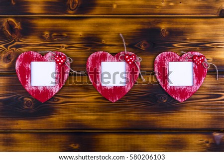 Love card template with blank photo frame heart shaped on the red hearts on burnt wood background