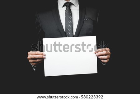 A business man holding a paper. Studio shot