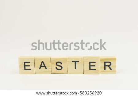 Text wooden blocks spelling the word easter on white background