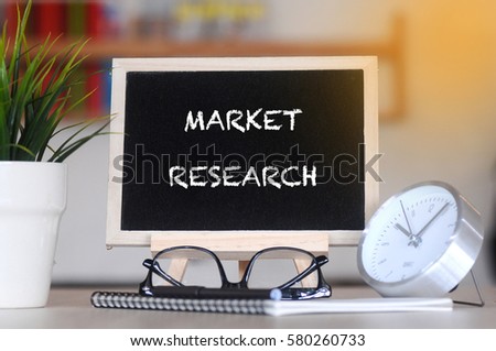 concept of coffee cup with stand board on blurred modern office background with MARKET RESEARCH word. tone image