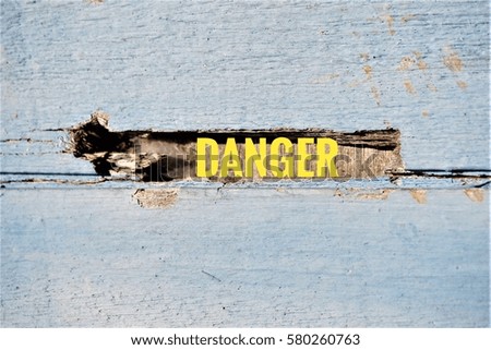 text Danger on wooden wall