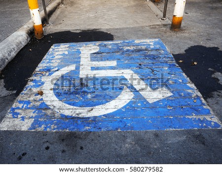 Wheelchair symbol in a Parking Lot marks disabled parking space.
