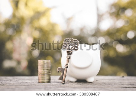 Old key coin piggy bank on wood a bokeh background with copy space a color of vintage tone selective and soft focus, concept save money