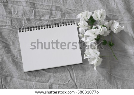 blank notebook with flowers on bed