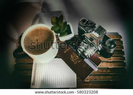 Top view of retro camera ,lens, passport and coffee  for travel inspiration
