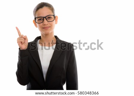Studio shot of young beautiful businesswoman pointing finger up