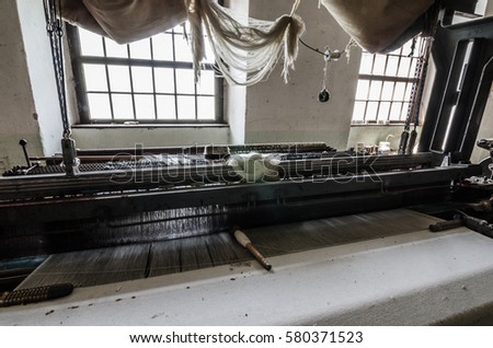 white fabric on a machine in old spinning mill