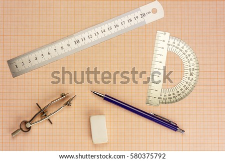 On graph paper are compasses, protractor, ruler, eraser and a pencil