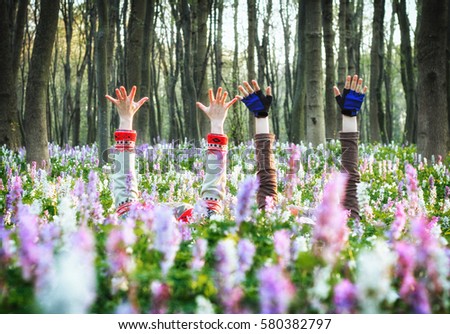 Two girls lying in blooming meadow. Conceptual photo. Spring is coming. Picturesque and gorgeous scene. Discover the world of beauty.