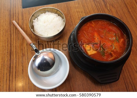 Korea Food in Restaurant on wooden table, spicy rice cake, grass noodles tofu vegetable in red hot soup