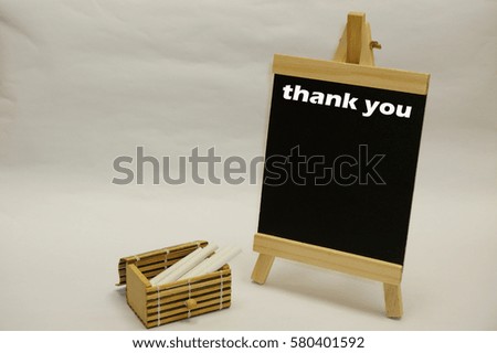 "Thank You" written on blackboard with chalks inside wooden box case isolated over white background
