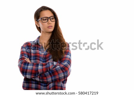 Studio shot of young beautiful woman thinking and looking down with arms crossed