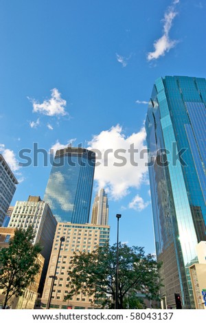 Minneapolis  skyline against a blue sky with white puffy clouds.