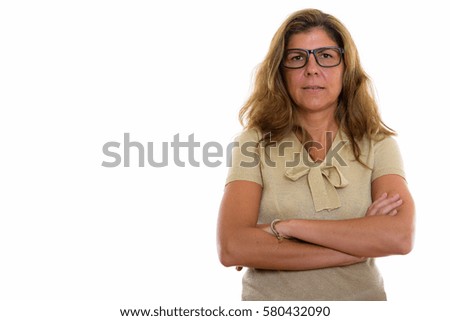 Studio shot of mature beautiful woman wearing eyeglasses with arms crossed