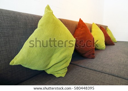 it is colorful pillows on long sofa for pattern and background.