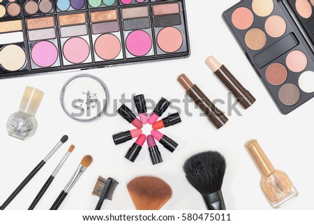 Collection of makeup cosmetics palette, lipstick, nail polish and brushes on white background 