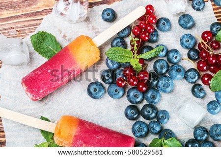 popsicles with berries and fruit on a wooden table