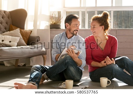 Happy middle aged couple enjoying free time at home Royalty-Free Stock Photo #580537765