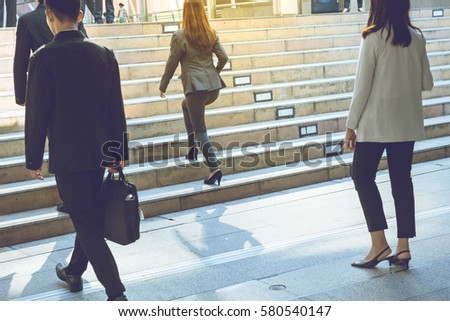 Business street in big city.After office work corporate building businessman walking quick steps some person hold business briefcase go down from stairs. Some person commute go home by car or walk .