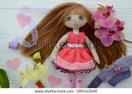 cute spring handmade doll and orchid on a white background