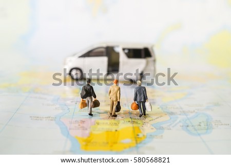 Miniature business people : businesses team walking to Luxury Van on world map with copyspace for travel around the world, business trip traveler adviser agency or online world wide marketing concept.