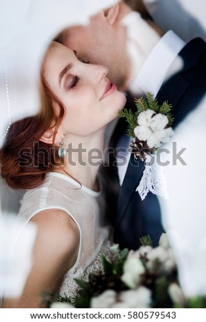 bride and groom kissing in wooden interior on winter rustic wedding