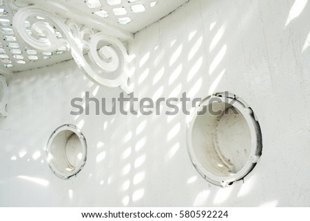 interior circular window with ornament detail of old white light house in madura east java indonesia south east asia captured in simple minimalist clean photograph with square net texture shadow