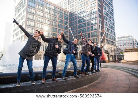 View of male friends standing one by one in London. Pointing away