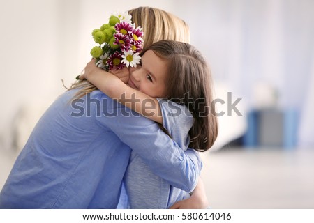 Cute little girl greeting her mother at home. Mother's day concept Royalty-Free Stock Photo #580614046