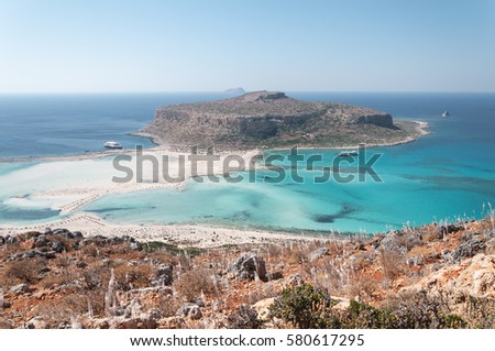 Crete, Greece. The famous lagoon of Balos formed between the Cape Gramvousa and the small Cape Tigani and below the range of Platiskino. Beach and water Royalty-Free Stock Photo #580617295