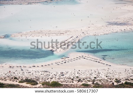 Crete, Greece. The famous lagoon of Balos formed between the Cape Gramvousa and the small Cape Tigani and below the range of Platiskino. Beach and water Royalty-Free Stock Photo #580617307